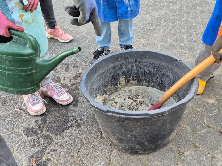 Wiederaufstellen der Holzfiguren vor der Schule